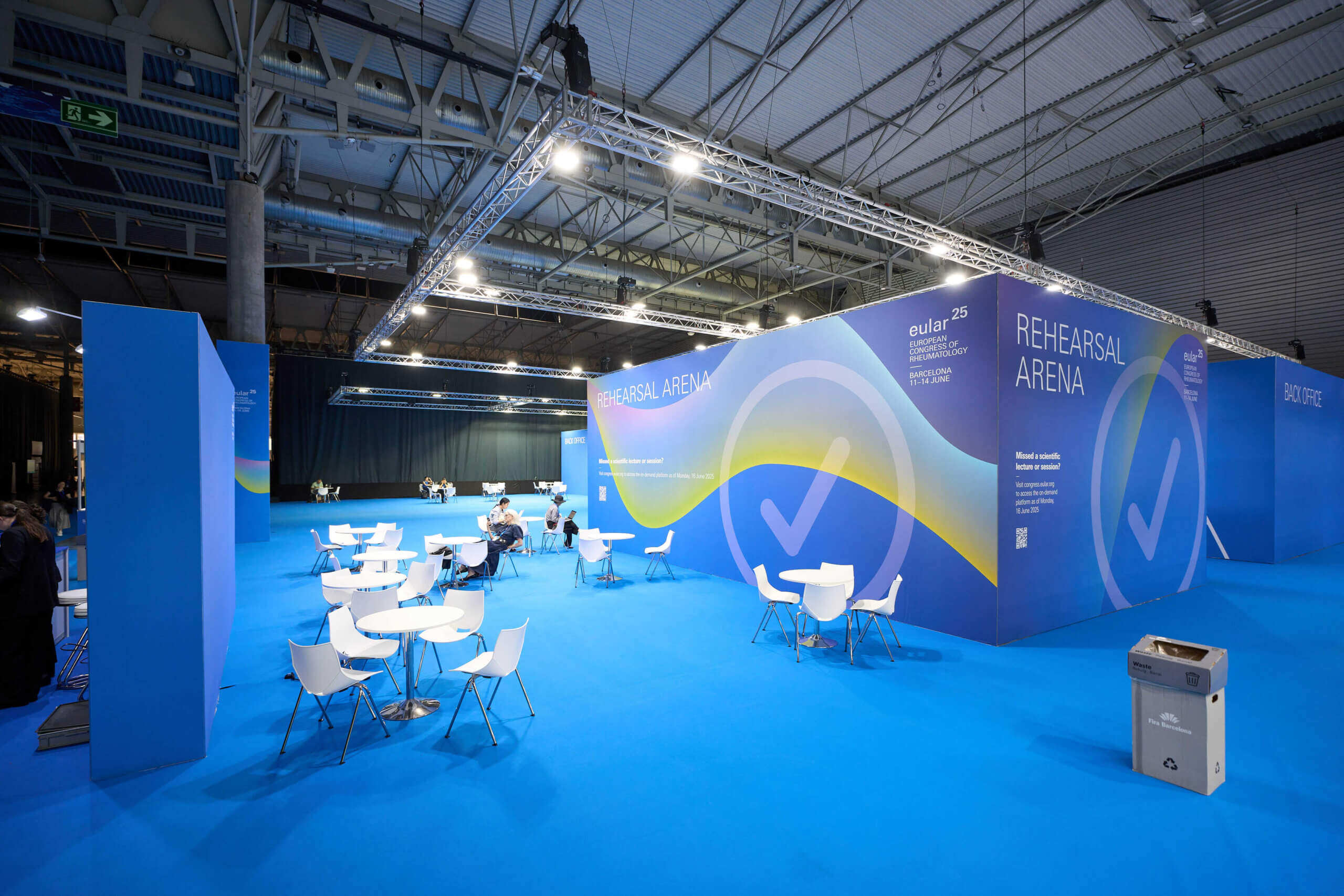 Vista frontal de la zona Speakers Management en EULAR 2025, con paneles azules y señalización clara para ponentes.