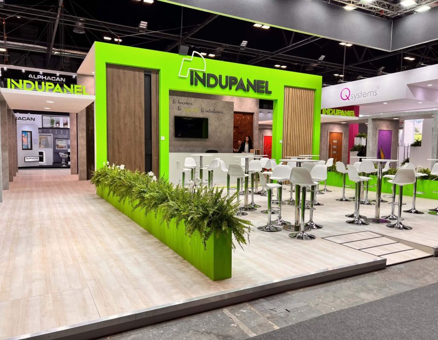 Stand de Indupanel en Construtec con diseño moderno en verde y zona de networking para visitantes profesionales