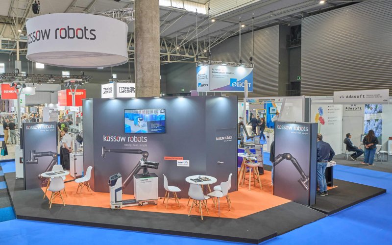 Espacio expositivo de Kassow Robots en Advanced Factories 2025, destacando brazos robóticos colaborativos y zona de reuniones.